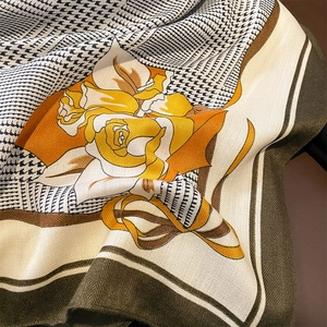 Detailed macro view of houndstooth weave and yellow rose print on soft scarf fabric