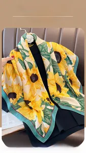 Close-up of sunflower print silk scarf showing fine green edges and vibrant floral pattern