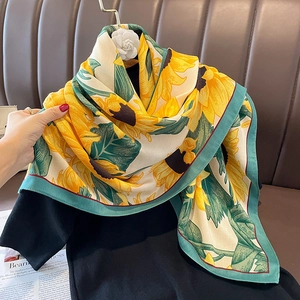 Elegant sunflower print silk scarf with teal borders styled on black shirt for women