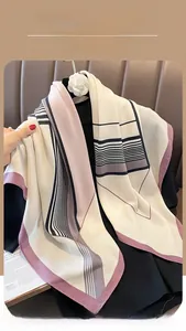 Detail of elegant striped geometric silk scarf draped over a black knit top
