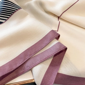 Elegant beige striped scarf with purple edges and detailed chevron weave pattern