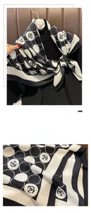 Detail view showing Camellia flower and dot pattern on a black and white silk scarf