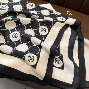 Detail of camellia flower print and polka dots on a premium black and white scarf