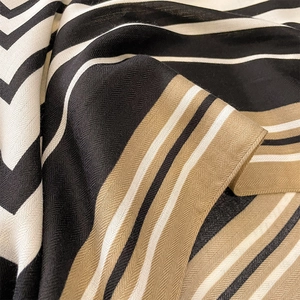 Macro view of striped wool-touch scarf showing zigzag patterns and herringbone texture
