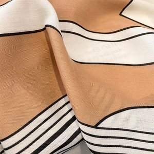Macro shot of striped scarf featuring detailed herringbone weave and silky texture