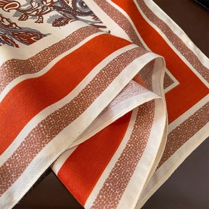 Detail of vintage paisley pattern and smooth rolled edges on soft orange scarf