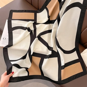 Detail eines Seidenschals mit Farblock-Muster in Schwarz Weiß und Camel-Ton
