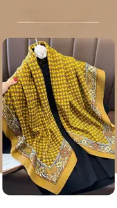 Detail of yellow silk scarf with vintage chain patterns on a black garment model