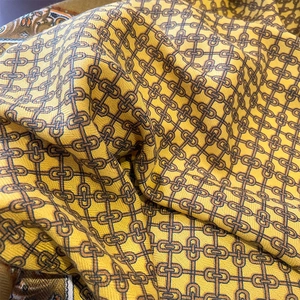 Detail of yellow vintage chain print silk scarf showing twill texture and soft drape