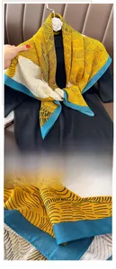 Detailed view of the fine edge stitching on the yellow and navy printed square scarf