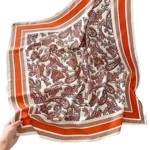 Orange and beige Paisley wool-touch scarf held by hand with vintage geometric borders