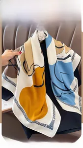 Detailed view of geometric print silk scarf with blue and ginger color block patterns