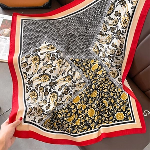 Detail eines rot-goldenen quadratischen Seidenschals mit Paisley-Muster und Blumendruck