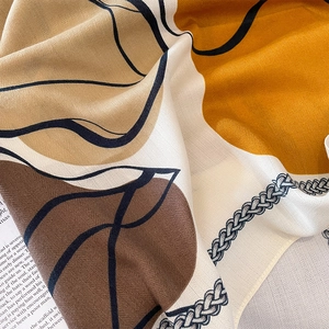 Chic 90cm square scarf featuring abstract golden yellow and black leaf patterns