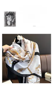 Detail of silk-like scarf featuring elegant yellow paisley patterns and black border accents