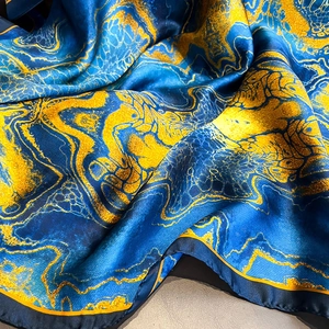 Eleganter Seidenschal mit blau-goldener Marmorierung und seidigem Glanz für Damen