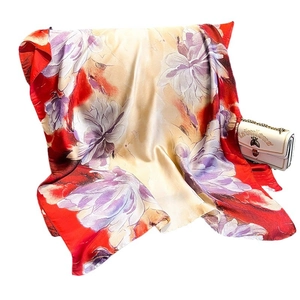 Elegant silk-like scarf with red and beige floral prints, paired with a white handbag