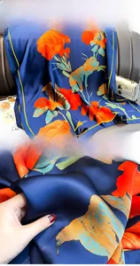 Gros plan détaillé d'un foulard en soie à fleurs avec bordure cousue et tissu bleu marine