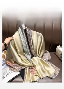 Detail of silk-like scarf with geometric chain prints draped over a leather sofa
