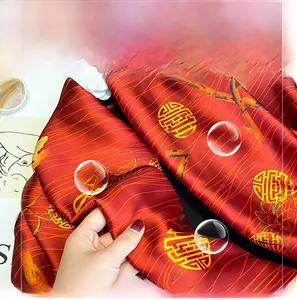 Detailed close-up of red silk shawl showing traditional bamboo and longevity patterns