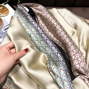 Satin silk scarf featuring a geometric chain pattern with high-gloss champagne gold finish
