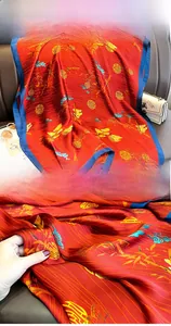 Detail of red silk scarf with golden bamboo patterns and high-quality hemmed edges