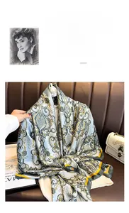 Détail d'un foulard en soie bleue avec motif paisley doré et bordure jaune