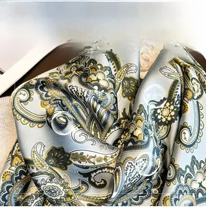 Gros plan sur un foulard en soie à motif paisley avec un fini satiné et brillant