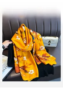 Dettaglio di sciarpa in seta gialla a fiori con trama satinata su sfondo in pelle