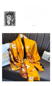 Dettaglio di elegante sciarpa gialla effetto seta con stampa di fiori di susino in raso