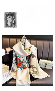 Detailed shot of satin floral scarf with red flowers and birds on a vintage leather chair