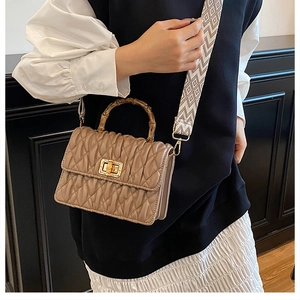 Chic pleated crossbody bag in khaki featuring a natural bamboo handle and jacquard strap