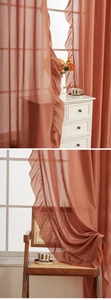 Detail view of brick red sheer curtain with ruffled edges and soft translucent fabric
