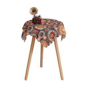 Bohemian mandala round tablecloth with vibrant orange and blue patterns on wood table