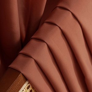 Caramel solid color sheer curtain with elegant ruffles and soft draped texture on a chair
