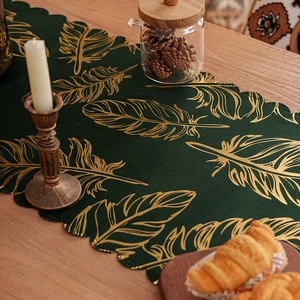 Dark green velvet table runner with gold feather patterns and wavy edges for home decor