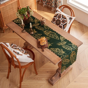 Dark green festive table runner with gold leaf patterns and elegant scalloped edges