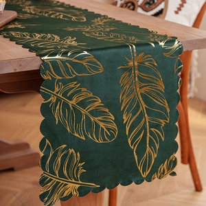 Dark green velvet table runner with gold feather pattern and scalloped edges for decor
