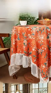 Detail of vintage orange crane floral tablecloth with white wide lace embroidery border