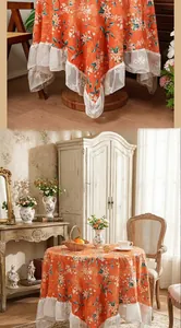 Detail of vintage orange floral tablecloth with elegant wide white lace trim