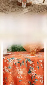 Macro detail of retro orange velvet tablecloth featuring floral and crane patterns