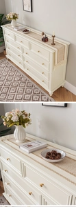 Detail of elegant cream white 9-drawer cabinet with gold handles and vintage wooden legs