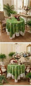 Detail of green floral round tablecloth with elegant wide white lace embroidery borders