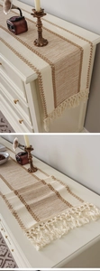 Detailed view of woven table runner with beige stripes and dense cotton fringe tassels