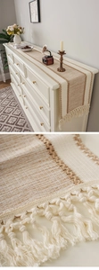 Close-up of bohemian table runner showing woven cotton texture and handmade long tassels