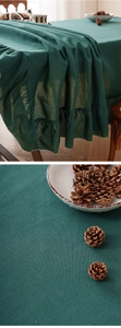 Detailed macro view of dark green linen tablecloth showing ruffled edge and fabric texture
