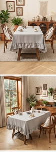 Detailed view of light gray linen tablecloth with ruffled edges and natural drape texture