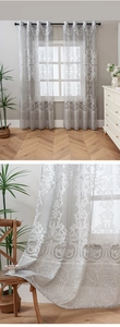 Detail of grey damask lace sheer curtain showing elegant floral pattern and light filtering
