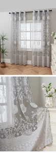 Detail of greyish white lace curtain with damascus patterns and rod pocket design