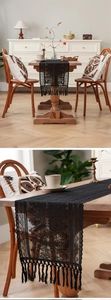 Close-up of black lace table runner featuring intricate floral crochet and long tassels